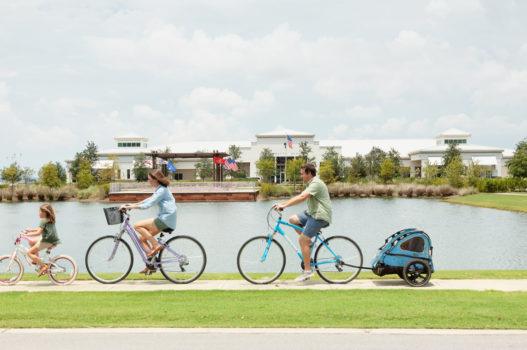 Family riding bikes along lake